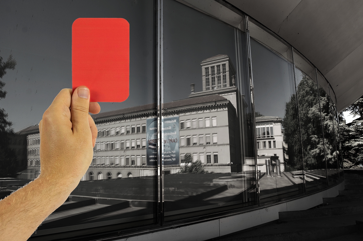 Hand holding red card superimposed on dark picture of WTO building