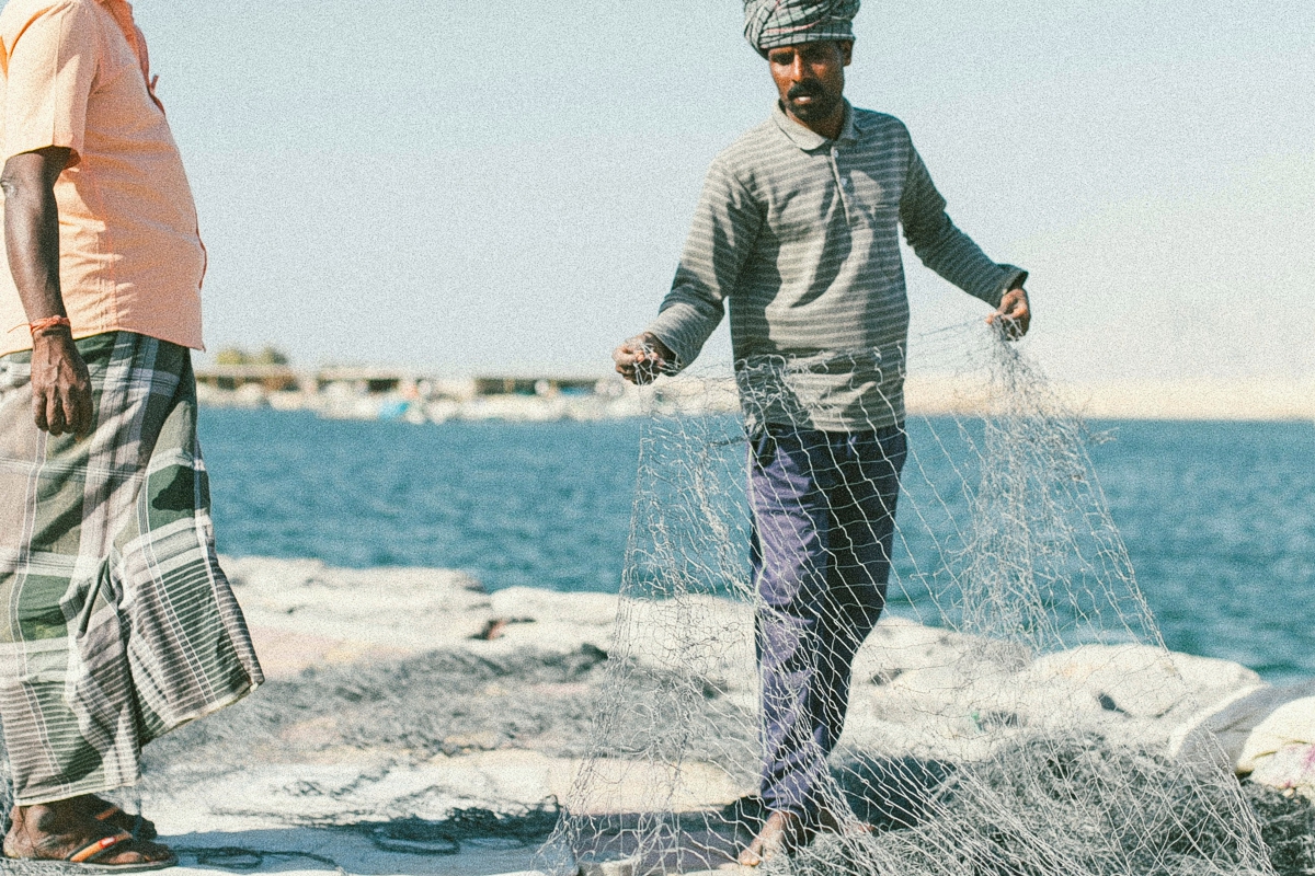 Photo of men working on fishing nets in UAE